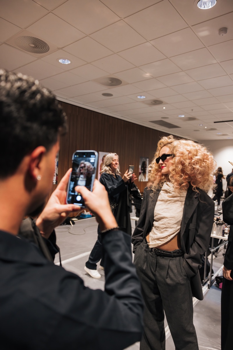 En frisyr fotograferas backstage på eventet